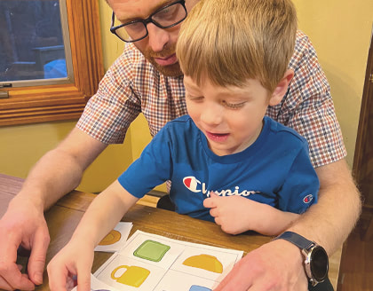 A father and son look at drawings of objects from an aerial perspective or bird’s eye view.