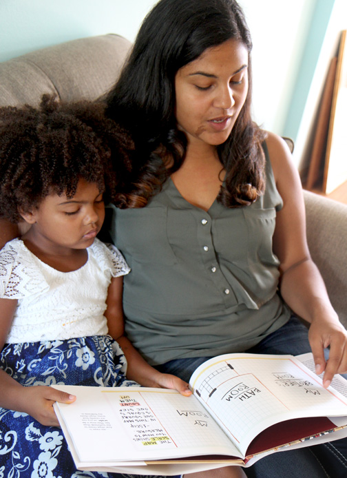 A mother and daughter read the book “Mapping My Day” by Julie Dillemuth.