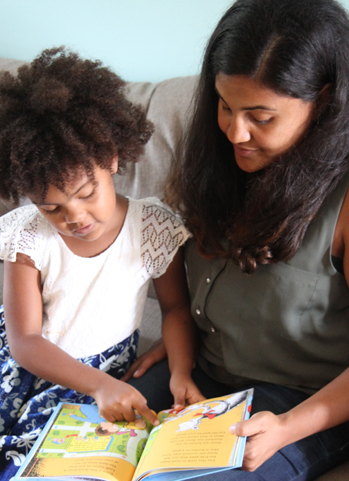 A mother and daughter read the book “There’s a Map on My Lap!” by Tish Rabe.