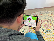 A man views digital apple trees through an iPad as he plays the Gracie & Friends “AR Adventures” augmented reality app.
