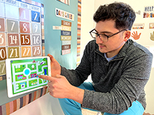 A man models playing city map game in the Gracie & Friends “Map Adventures” preschool spatial thinking app.