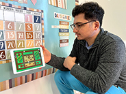 A man models playing goat challenge game in the Gracie & Friends “Map Adventures” preschool spatial thinking app.