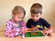 A boy and girl play the Gracie & Friends “Map Adventures” preschool spatial thinking app.