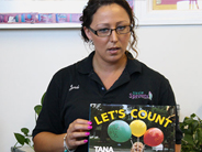A teacher holds up a the book Let’s Count.