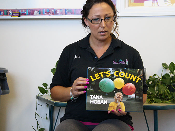 A teacher holds up a the book Let’s Count.