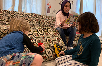 Parent reading out loud while children act out the story.