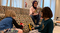 Parent reading out loud while children act out the story.