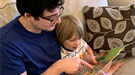 Parent and child reading a book.