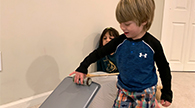 Child rolling a spice jar down a baking tray.