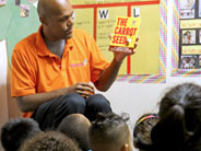 Teacher holding up The Carrot Seed book in front of class.