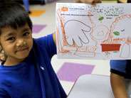 Student holds up colorful worksheet.