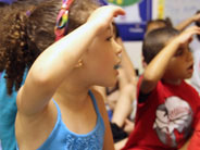 Children act out the steps of planting and caring for a seed.