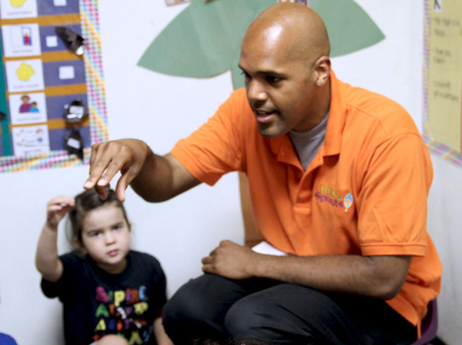 Teacher and students act out the steps for planting a seed.