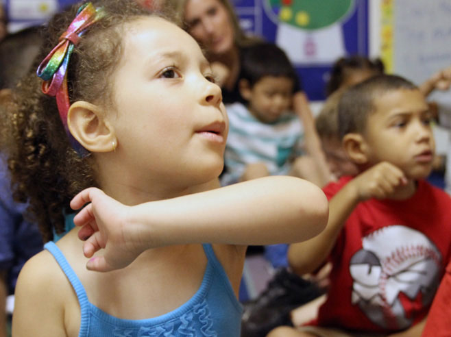 Students act out the steps for planting a seed.