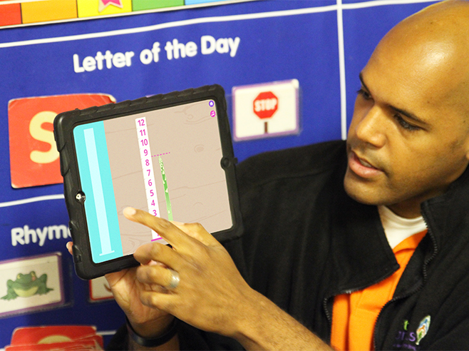Teacher showing Farmers Market app on iPad.