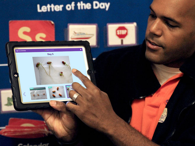 Teacher shows app to students.