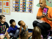 A teacher shows an iPad app to students.