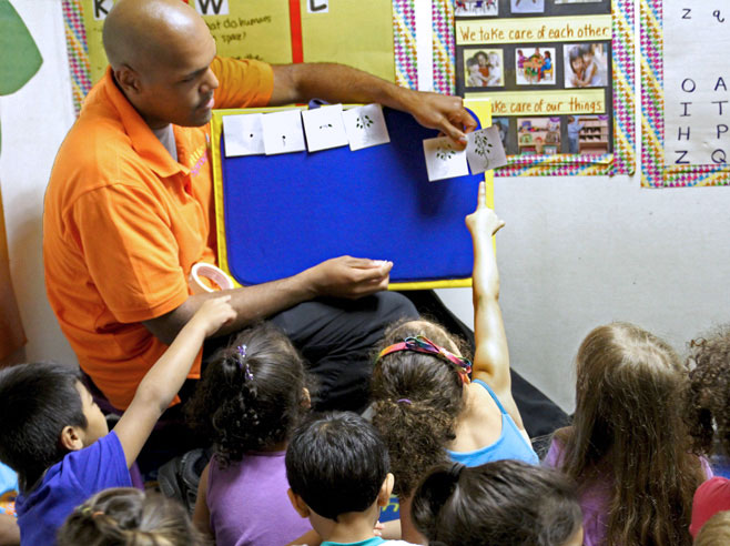 Teacher and students put cards showing the growth process of a plant in order.