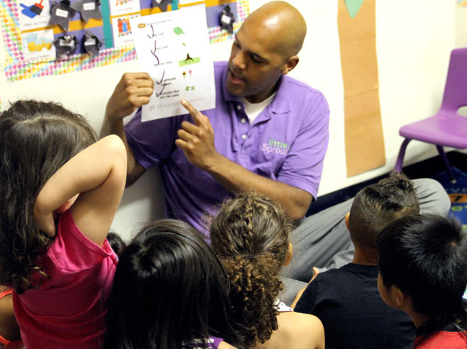 Teacher shows students paper from their Nature Scavenger Hunt.