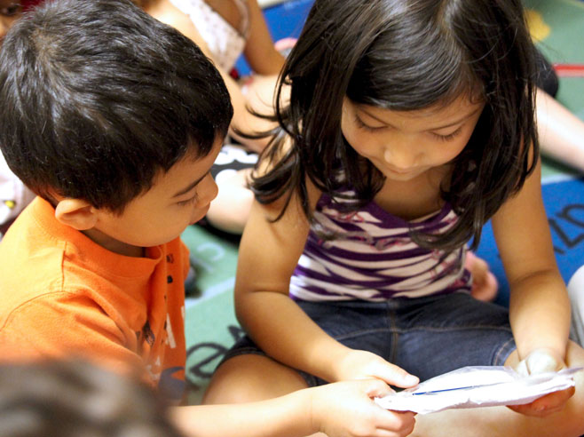 Students examining beans in a bag.
