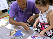 Teacher helps student draw sprouting seeds.