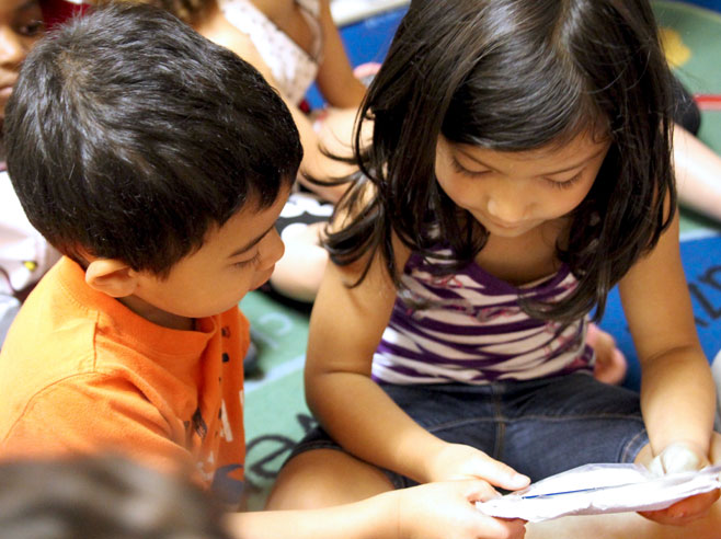 Two students looking at bag of seeds together.