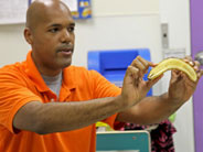Teacher holds up a banana sliced in half.