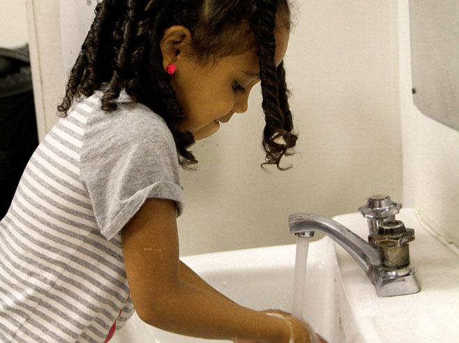 Student washes her hands.