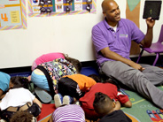 Students act out the sequence of a bean growing into a plant.