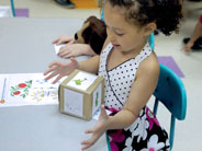 Student looks at a giant dice after rolling it.