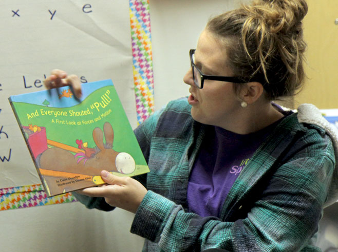 Teacher holding up a book.