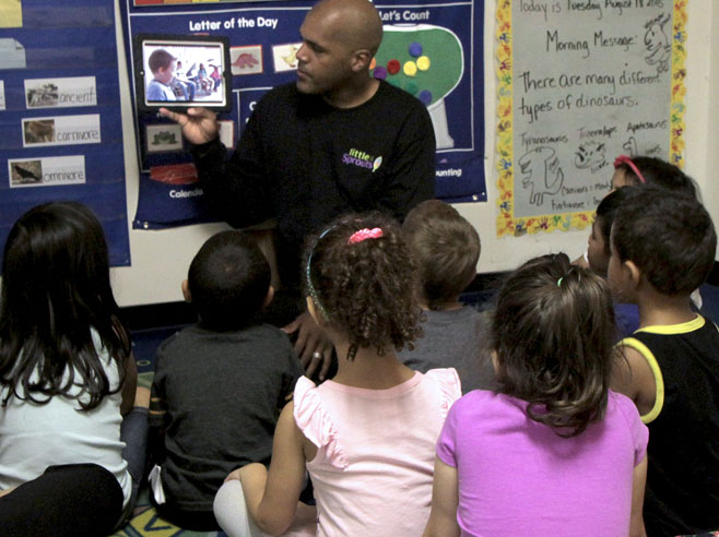 A teacher showing his class a video on the iPad