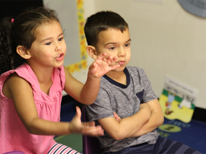 Two students talking and gesturing.