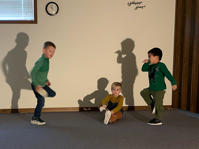 Light shining on students posing and their shadows.