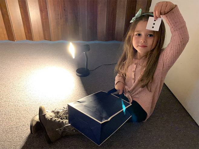 Student picks a card with three dots from a bag.